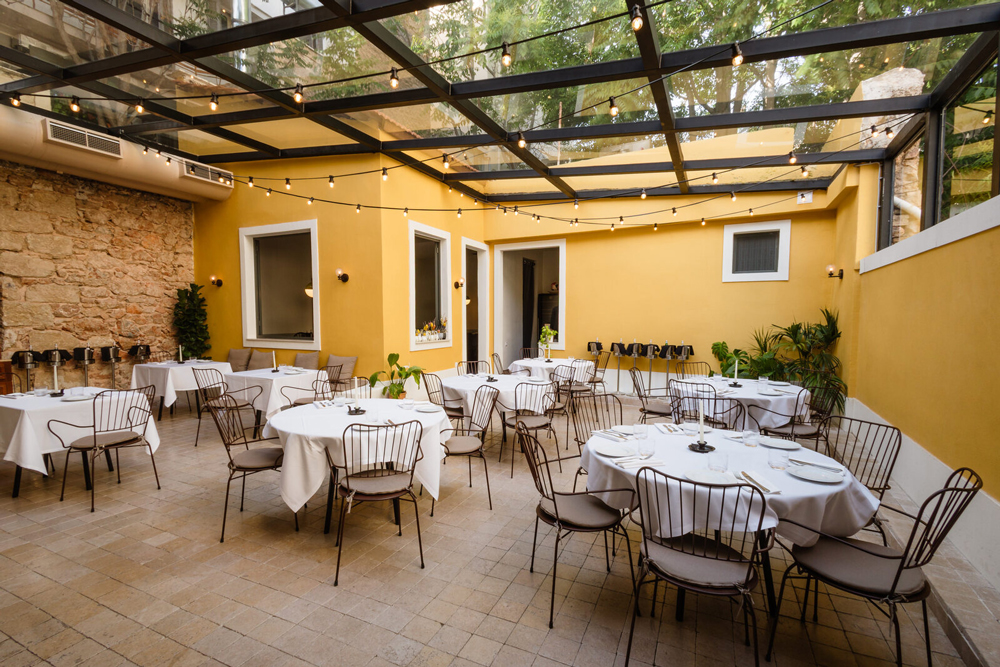 Semi-open courtyard under a glass ceiling with natural light filtering through.