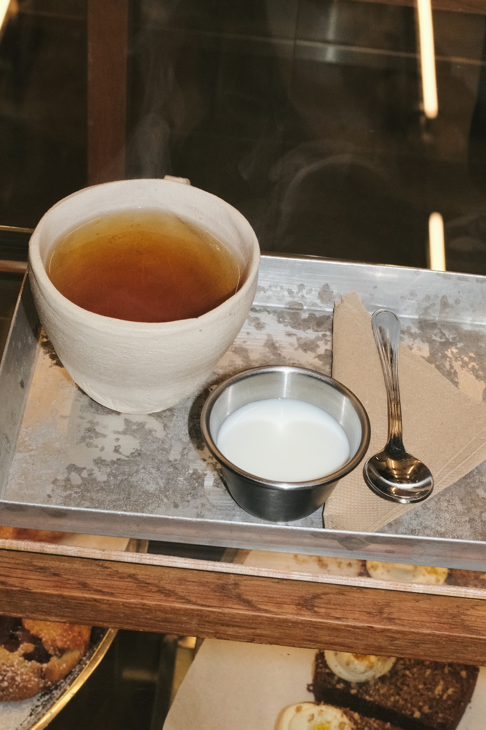 Herbal teas arranged next to baked goods on the self-service table.