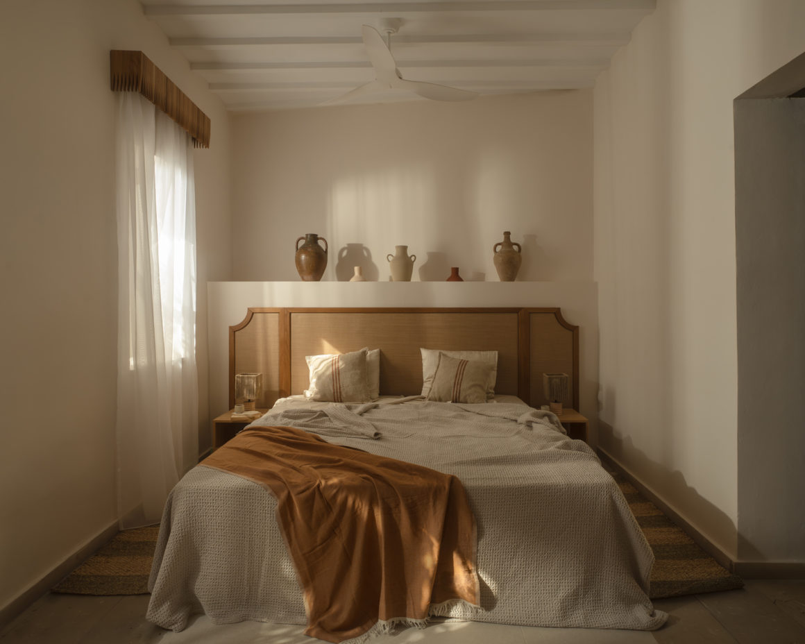 Bedroom at Amarakos with custom wooden furniture and textured linen fabrics.