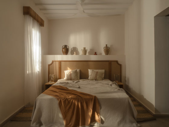 Bedroom at Amarakos with custom wooden furniture and textured linen fabrics.