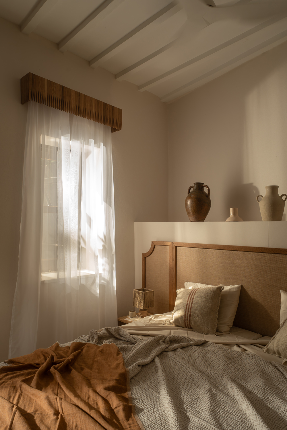 Minimal interior by Studio ADCH featuring stone walls, warm wood finishes and soft natural light.