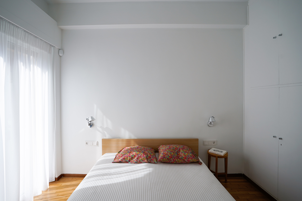 Bedroom in renovated Athens apartment blending 70s textures with clean industrial details.