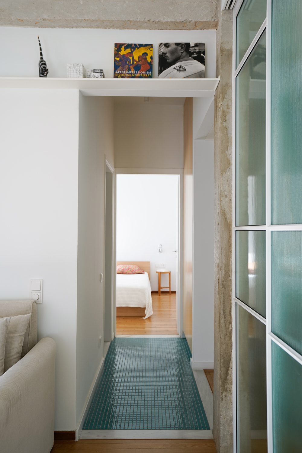 Turquoise tesserae tiles and birch veneer cabinetry in the apartment’s entrance hallway.