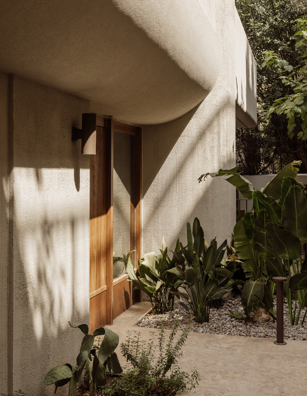 Exterior view of Block722’s Lumen residence, featuring clean geometric lines, warm timber accents and Mediterranean planting.