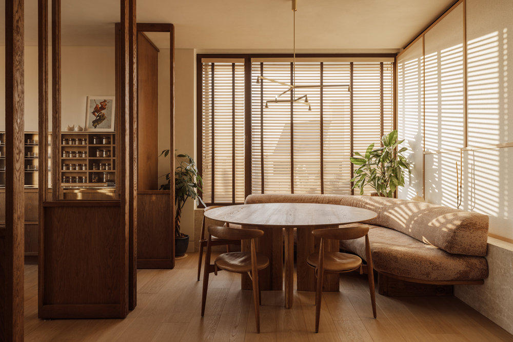 Minimal kitchen with marble surfaces and integrated dining area, designed in Block722’s organic luxury style.
