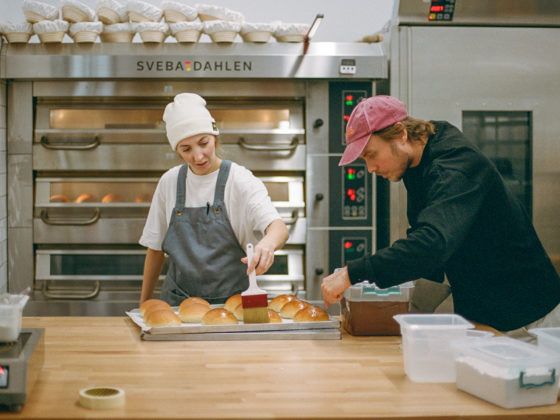 Bakers shaping artisanal loaves at Hygge, inspired by Nordic bread-making practices.
