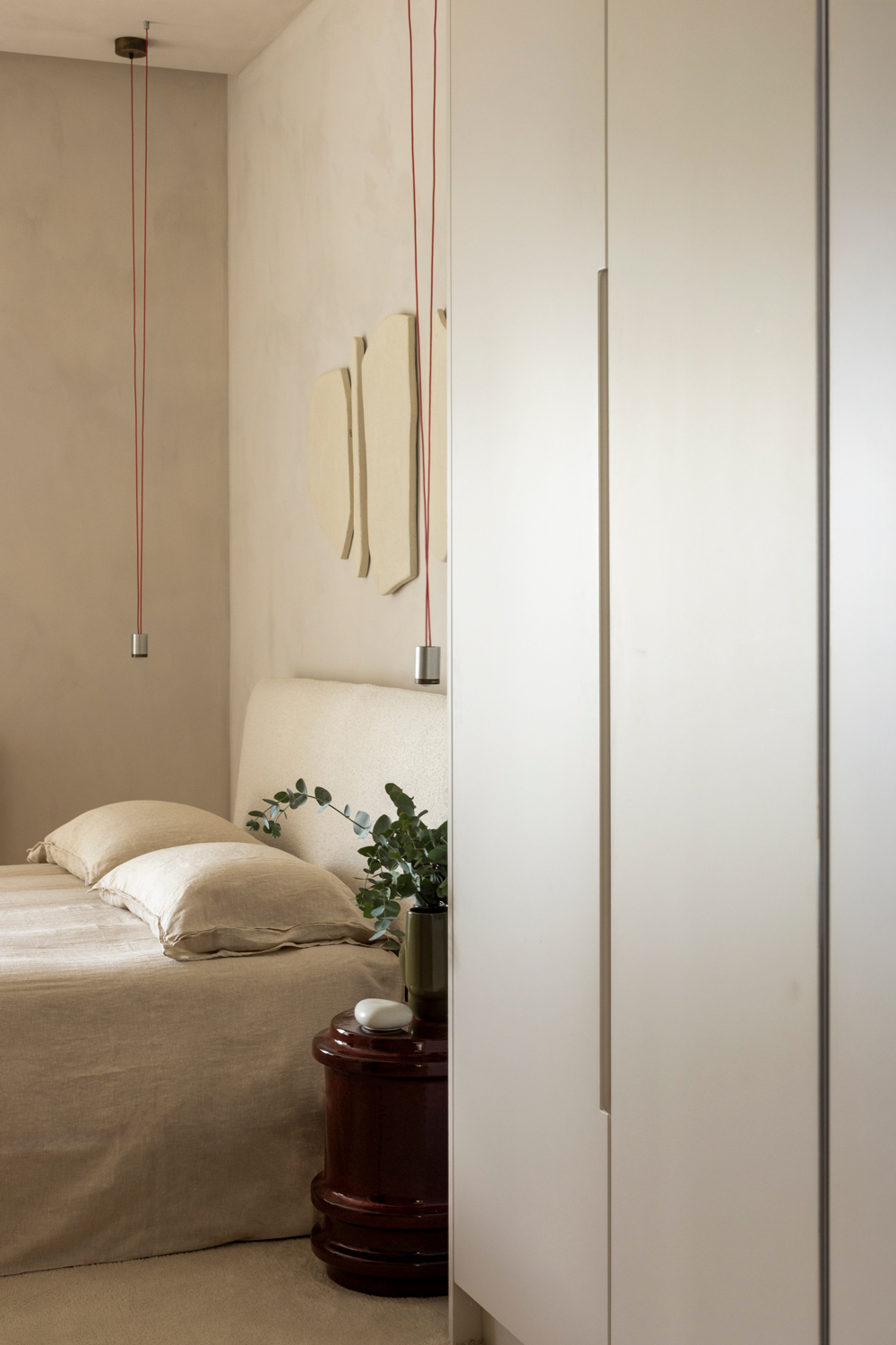 Serene bedroom with off-white carpet, beige lacquered furniture and soft natural lighting.