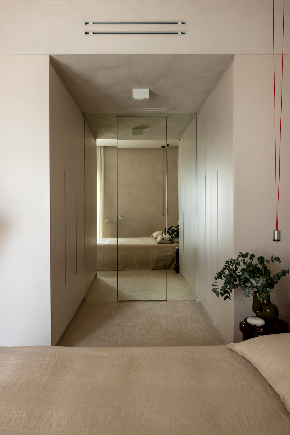 Serene bedroom with off-white carpet, beige lacquered furniture and soft natural lighting.