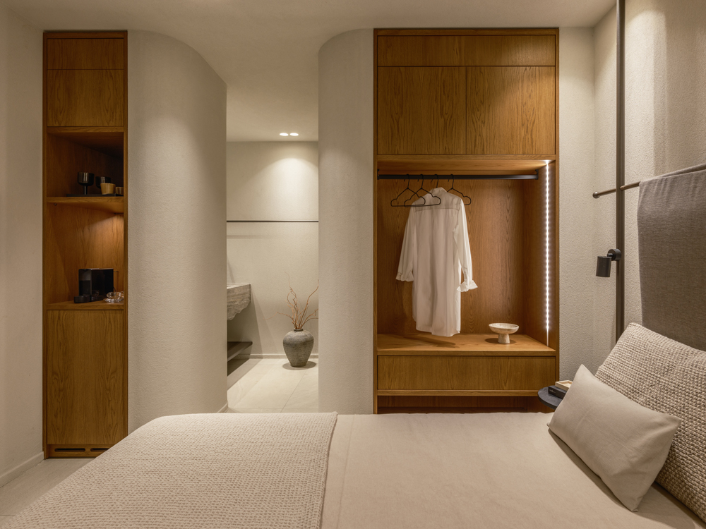 Bedroom with custom built-in oak veneer furniture and minimalist décor.