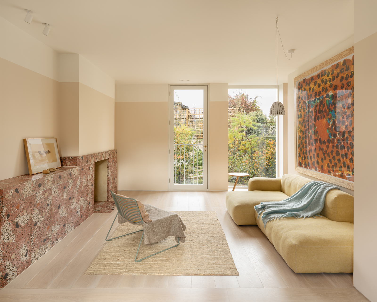 Living room vignette with contemporary artworks on a terrazzo-backed display wall.