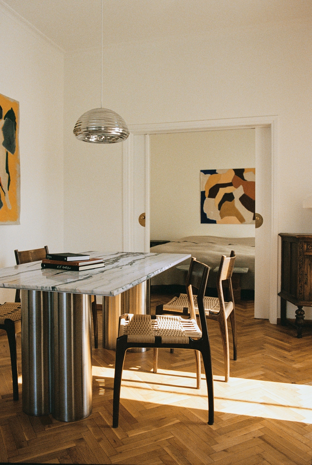 Dining table with fused column base and marble top, surrounded by 1960s Havana chairs