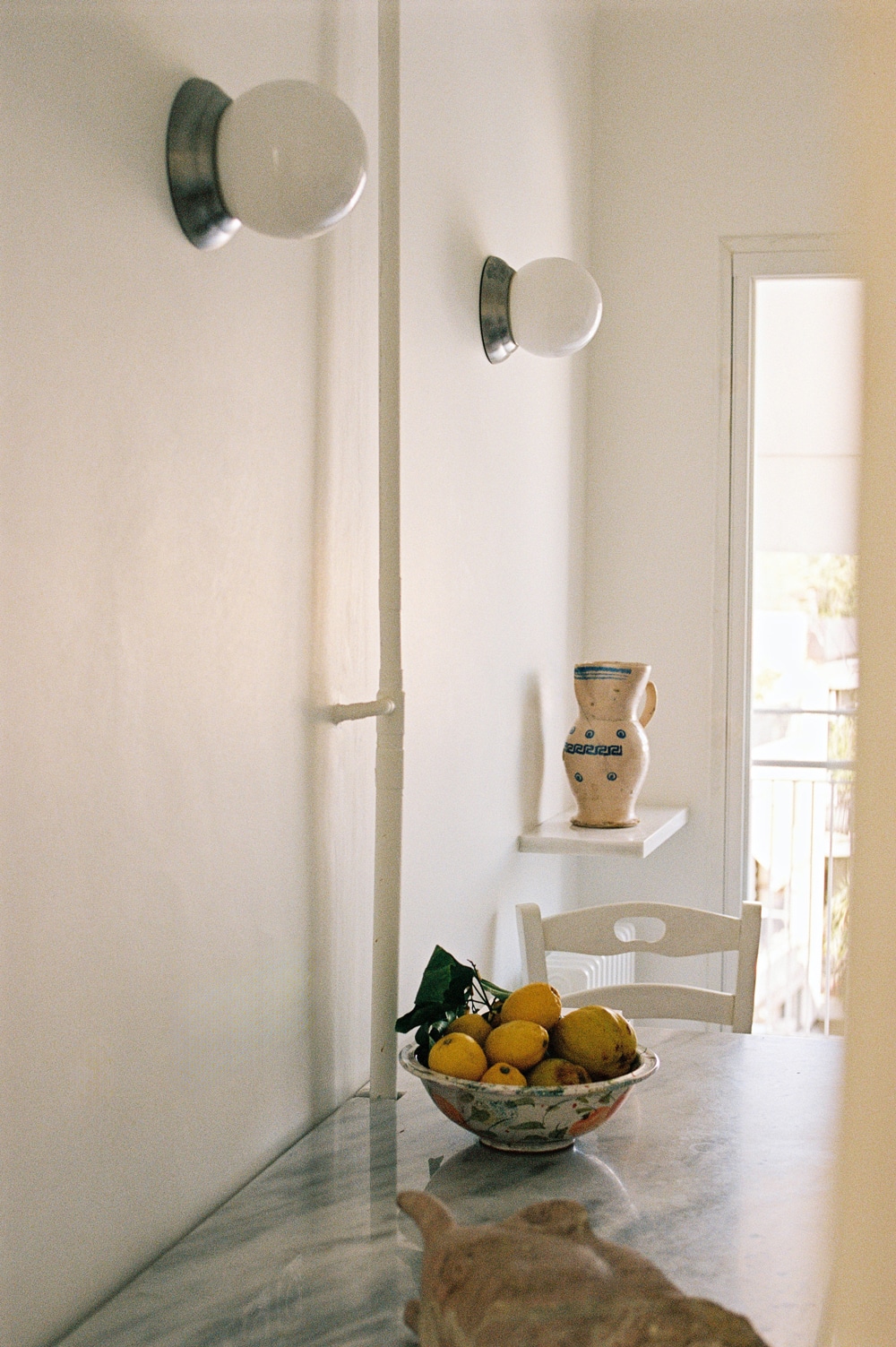Kitchen with original pink Skyros marble floor and island-style wooden cabinetry.