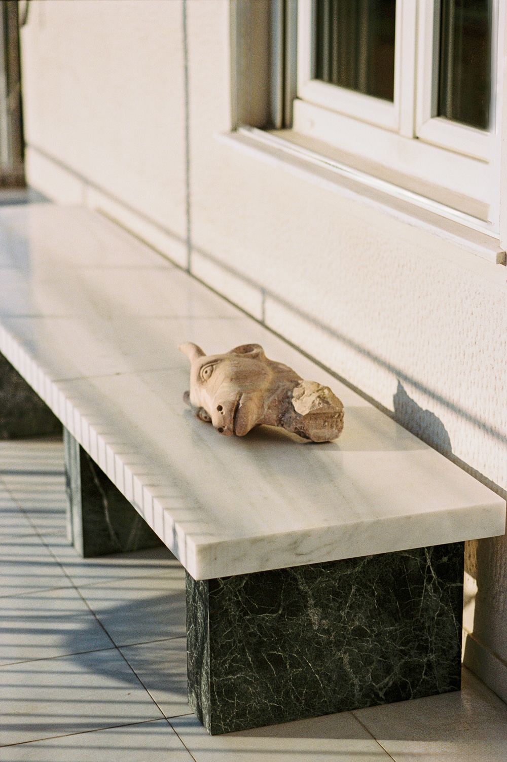 Outdoor seating area framed by Tinos green marble details.