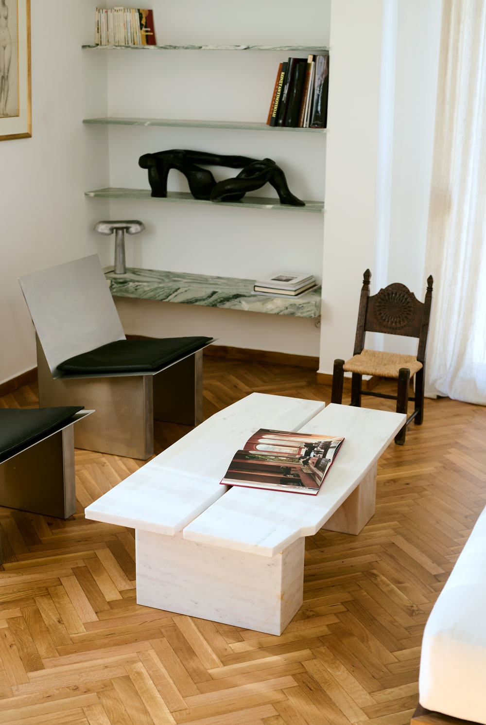 Living room with Dionysos marble coffee table and brushed stainless-steel armchairs.