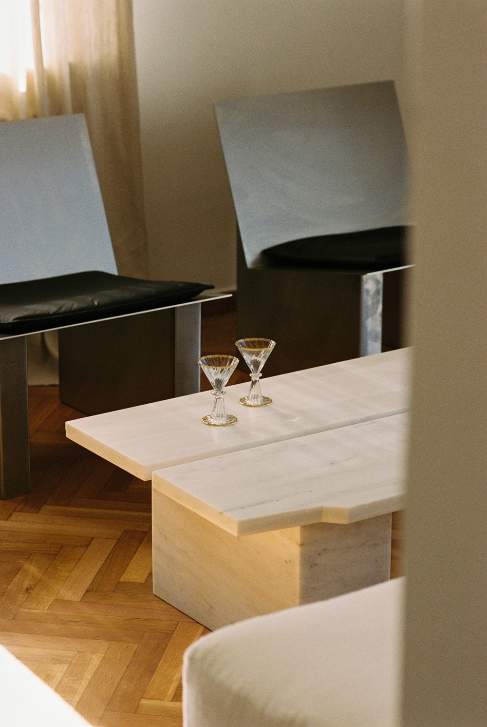 Custom walnut sofa and cipollino marble side tables in the penthouse living area.