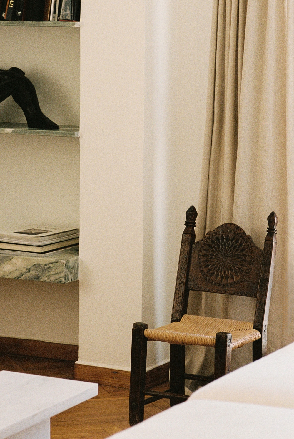 Custom walnut sofa and cipollino marble side tables in the penthouse living area.