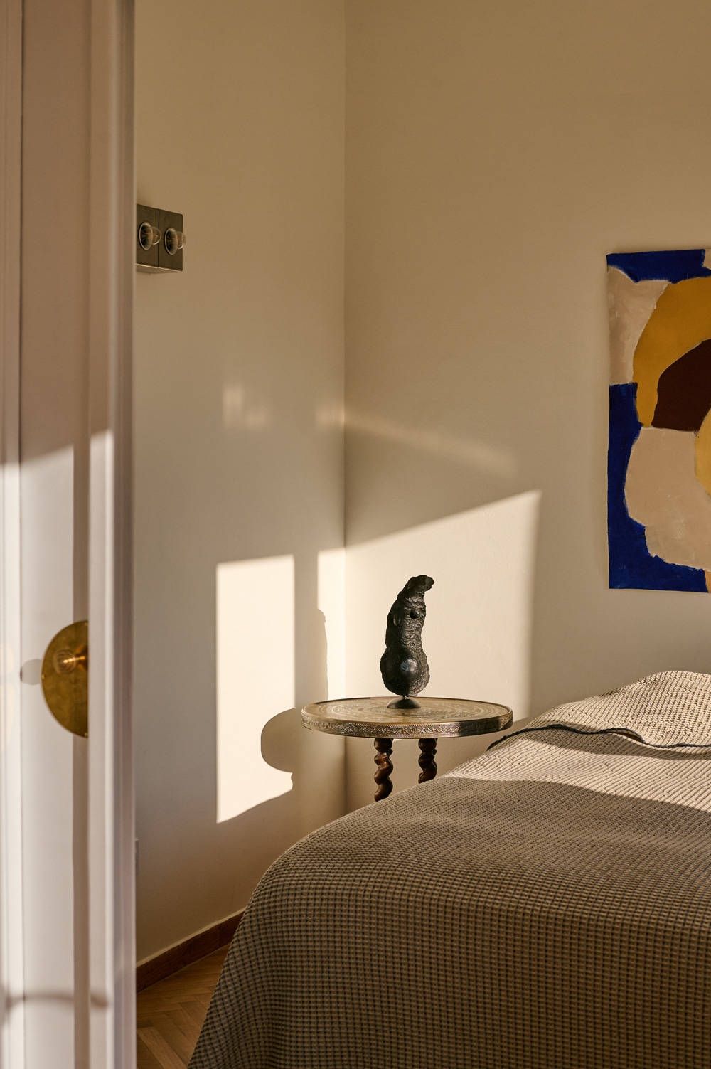 Minimal sleeping area featuring custom wooden furniture and soft natural tones.