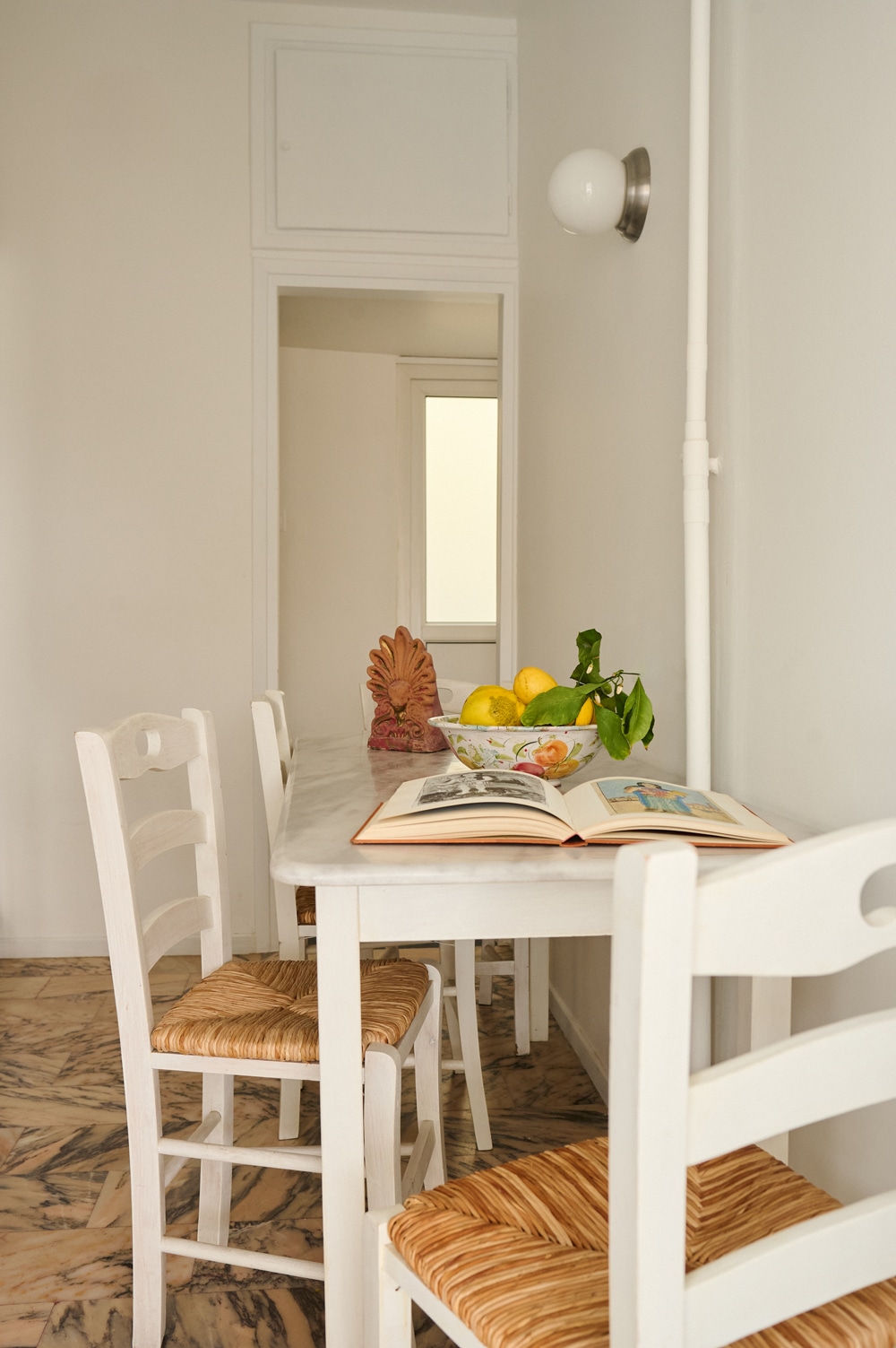 Kitchen with original pink Skyros marble floor and island-style wooden cabinetry.