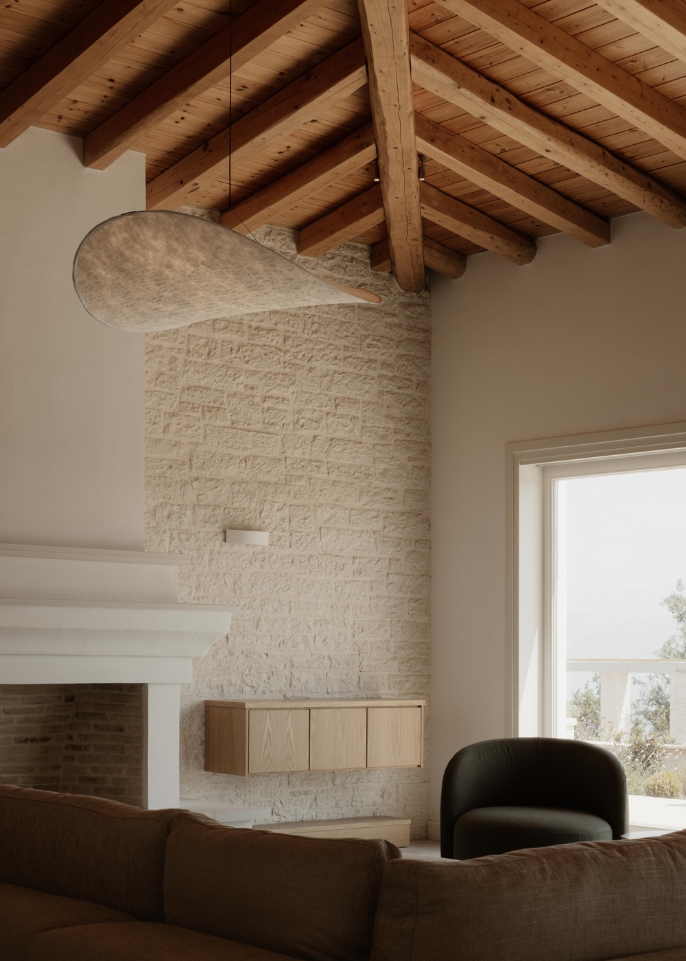 Living space with exposed timber ceiling and stone walls