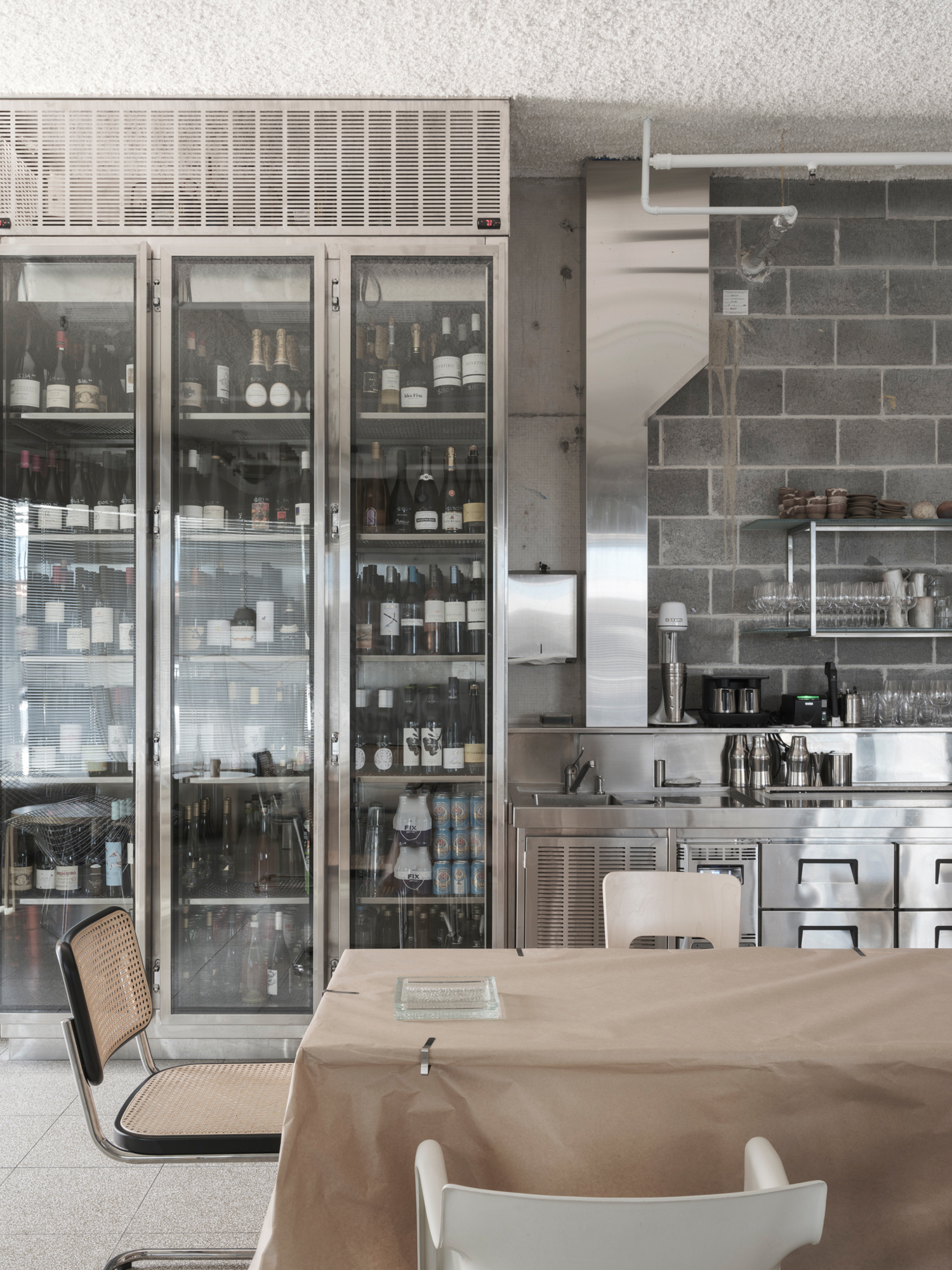 Stainless steel kitchen counter and bar seating at Homer Rogue Taverna by AP Design House