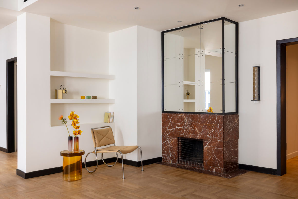 Living area with original oak flooring and red marble fireplace in renovated Kolonaki apartment