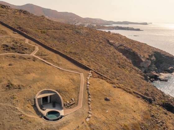 Exterior view of Olen Syros hotel embedded into the rocky hillside overlooking the Aegean Sea in Syros, designed by ATENO.