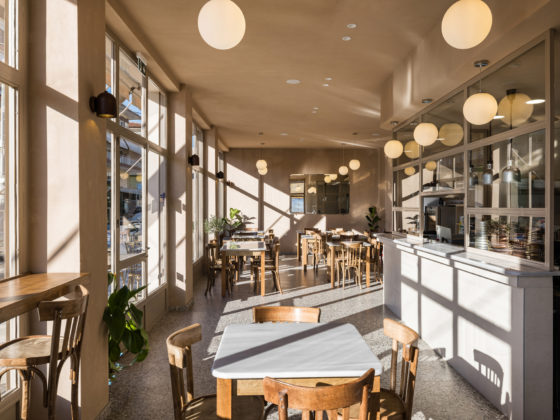 Interior view of FAI restaurant in Veroia with curved walls, terrazzo flooring and central open kitchen