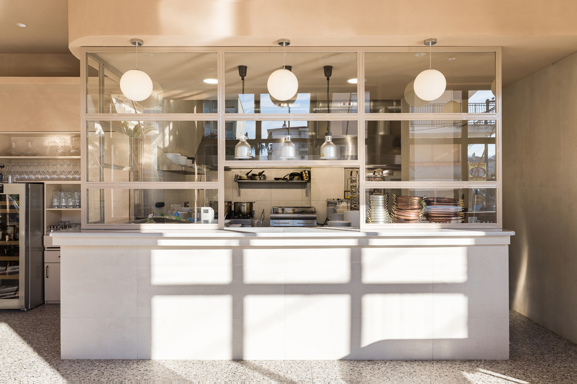 Open kitchen at FAI restaurant by Chrysanthi Karta visible from dining area with marble countertops