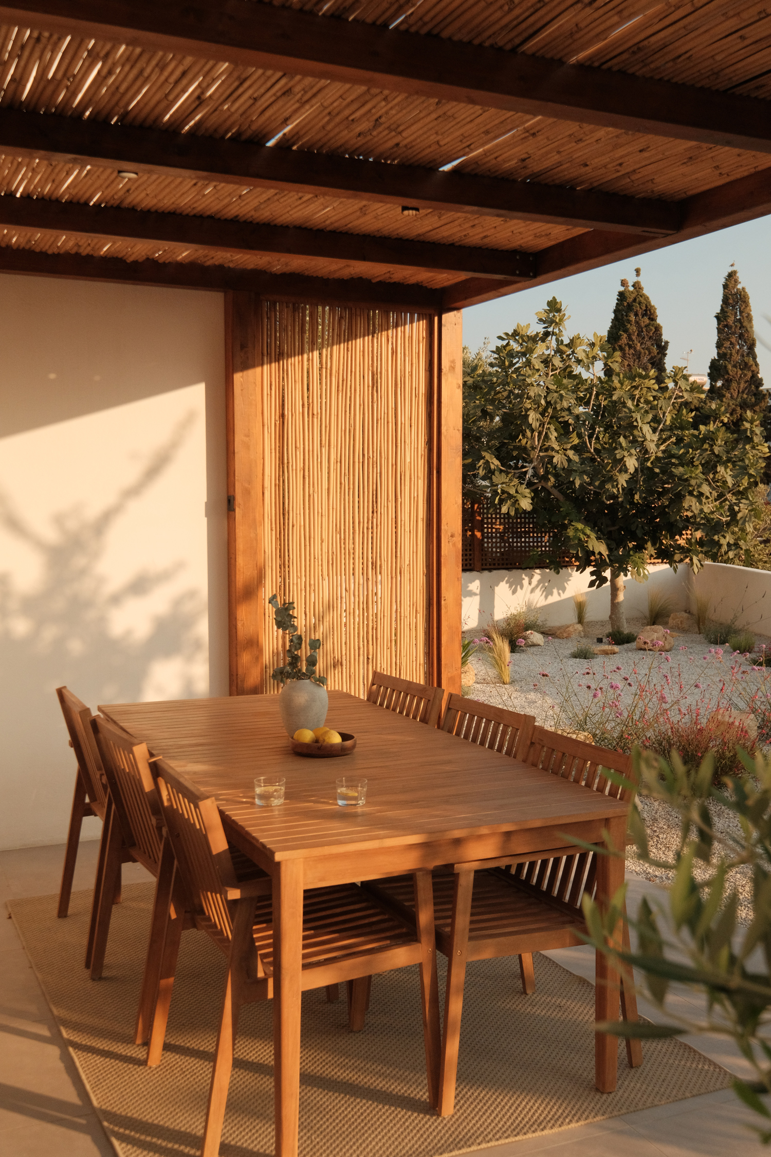 Shaded outdoor seating area beneath wooden pergola in Paros villa