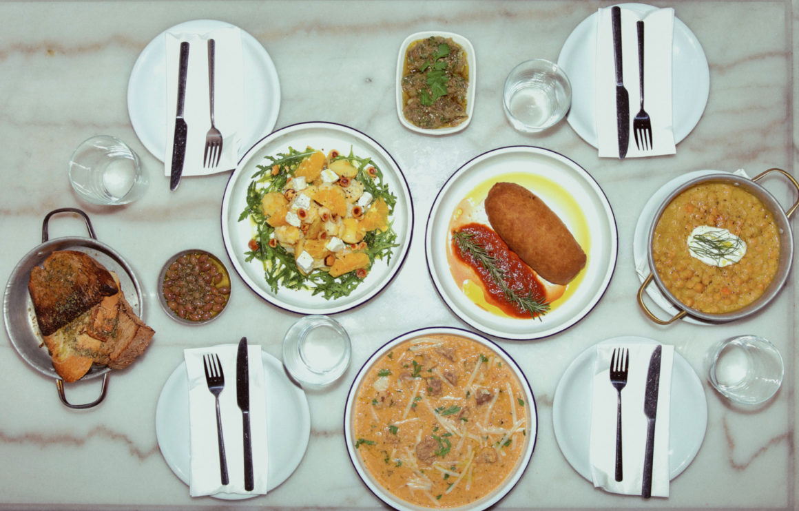 Rustic dining table at Athos featuring shared Greek dishes