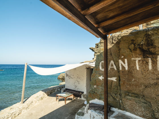 Exterior view of Cantina restaurant set against the rocky coastline of Sifnos