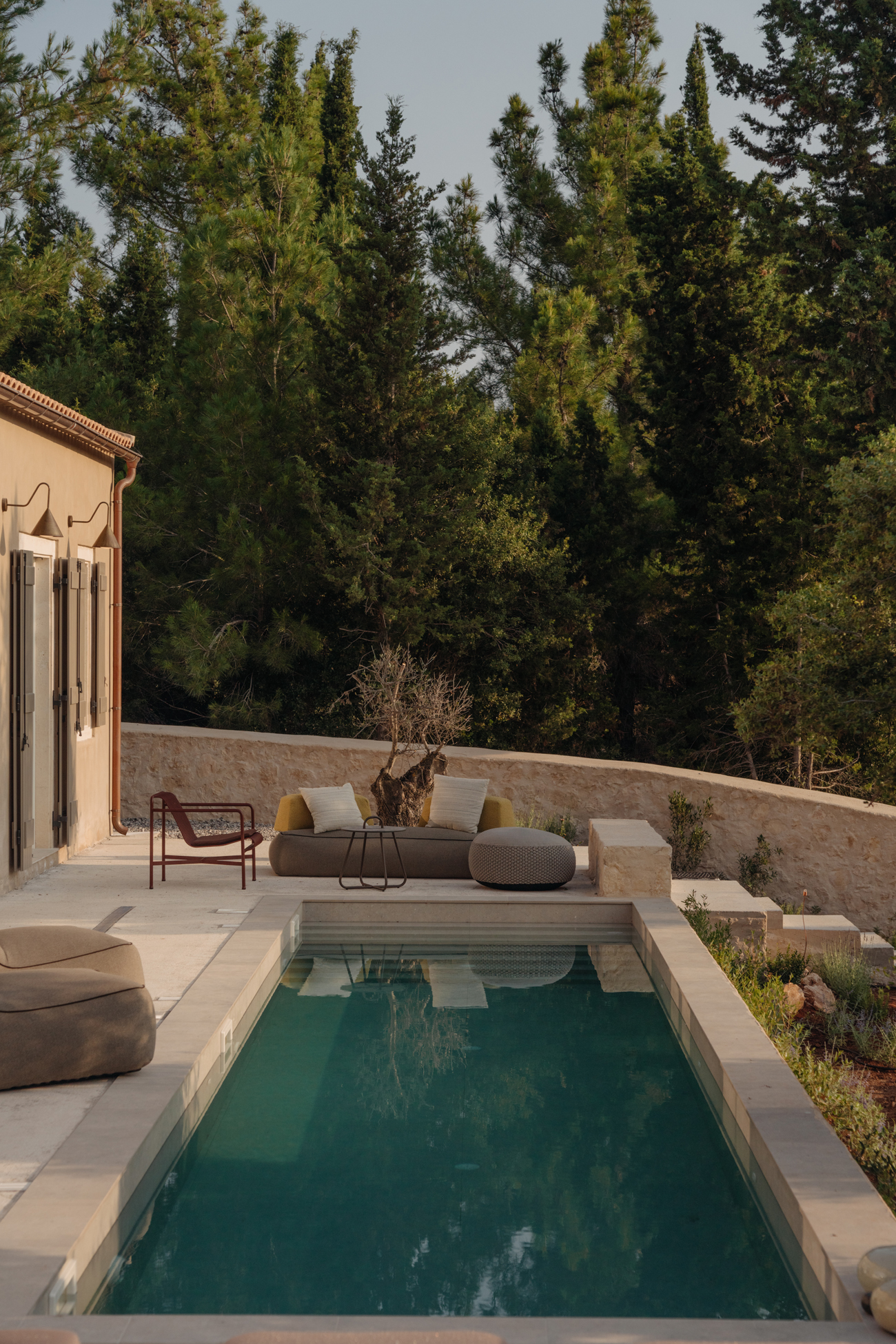 Two low lying villas arranged around a historic stone structure in Kefalonia