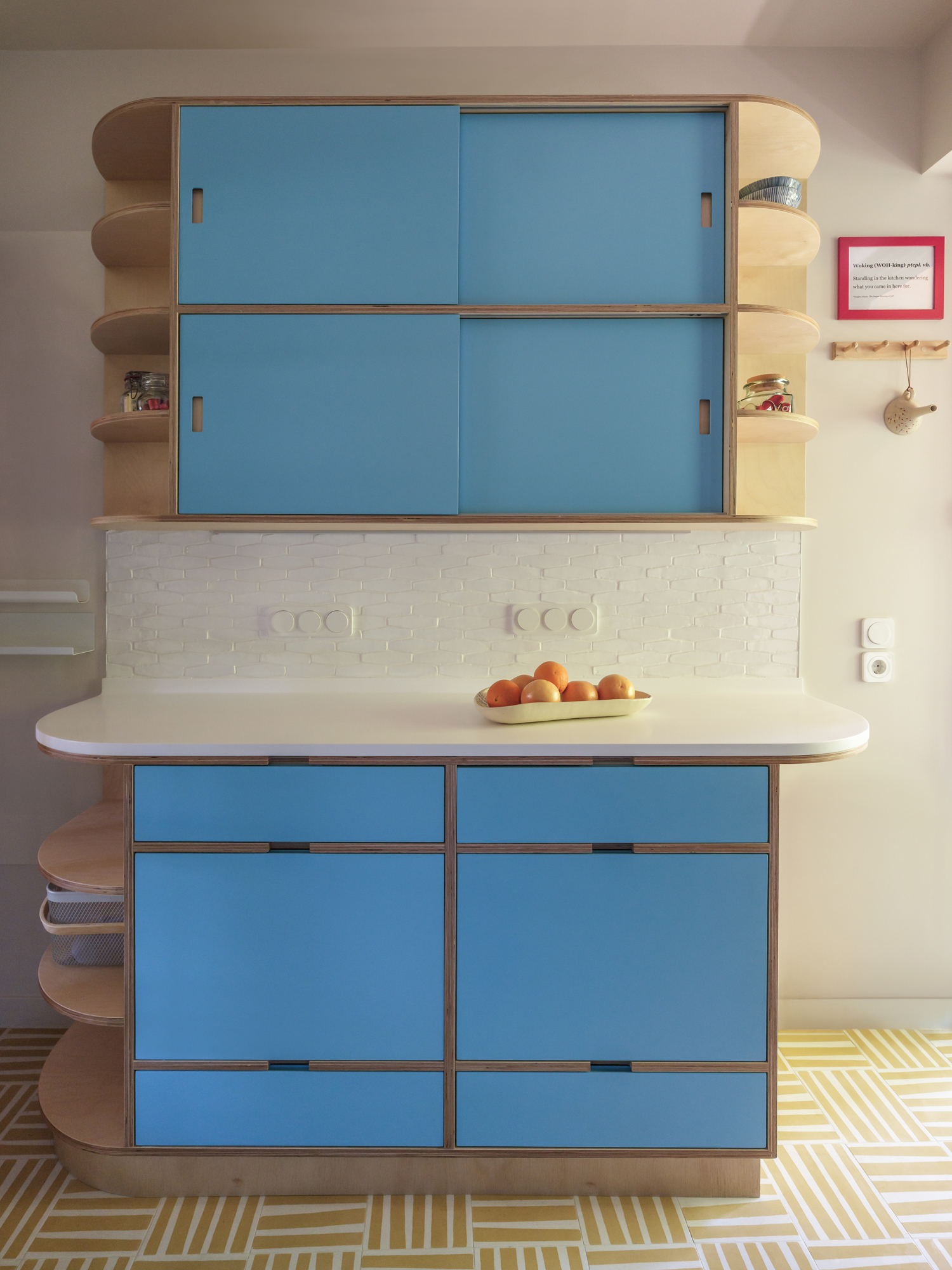 Plywood kitchen cabinetry and compact dining area inside renovated apartment in Larisa
