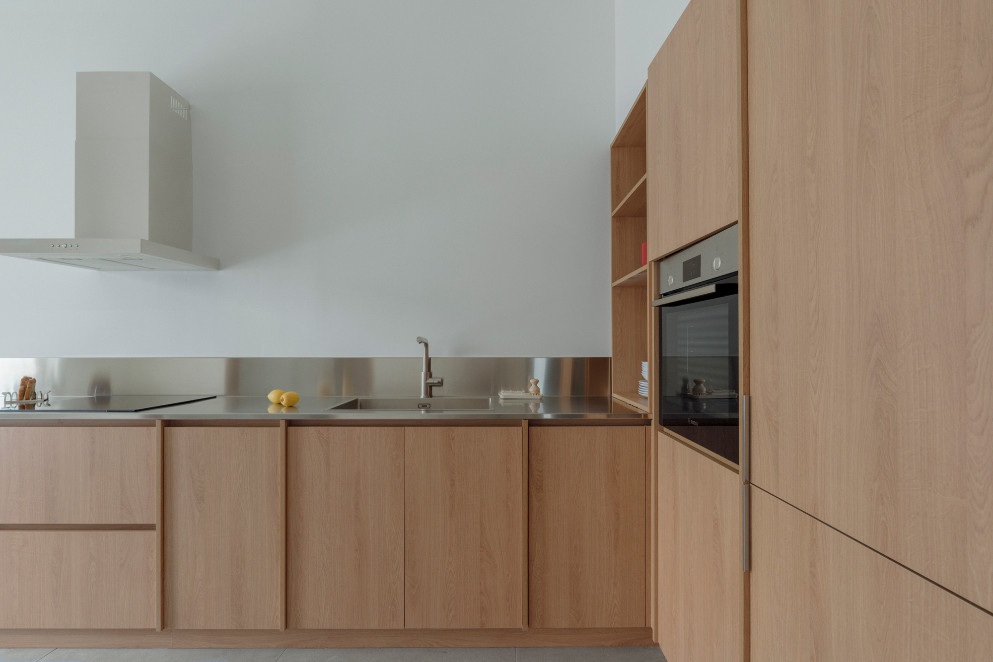 Kitchen extended towards the entrance with minimal detailing and neutral material palette