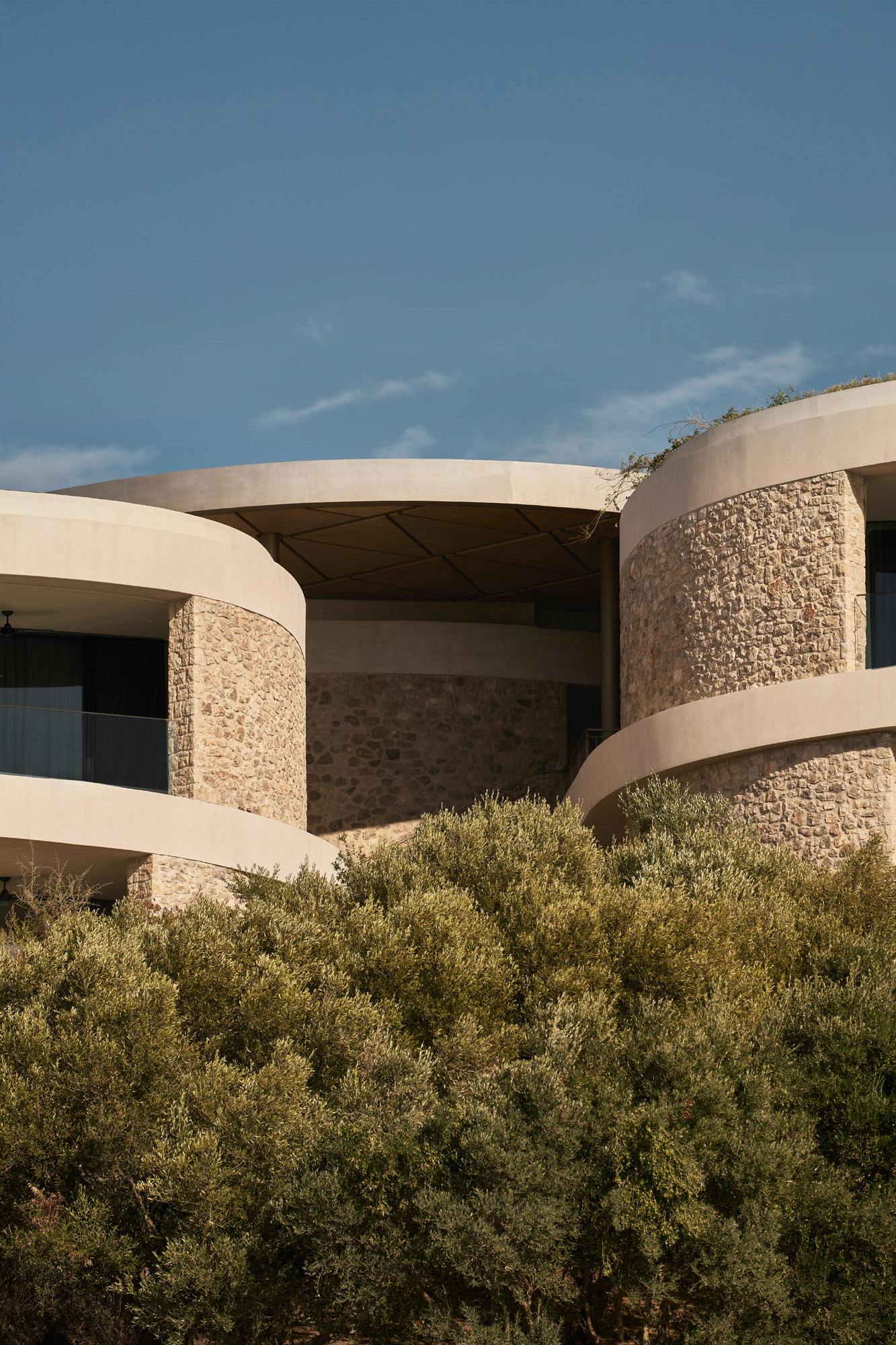 Exterior view of stone-clad villas at Mandarin Oriental Costa Navarino surrounded by Mediterranean planting
