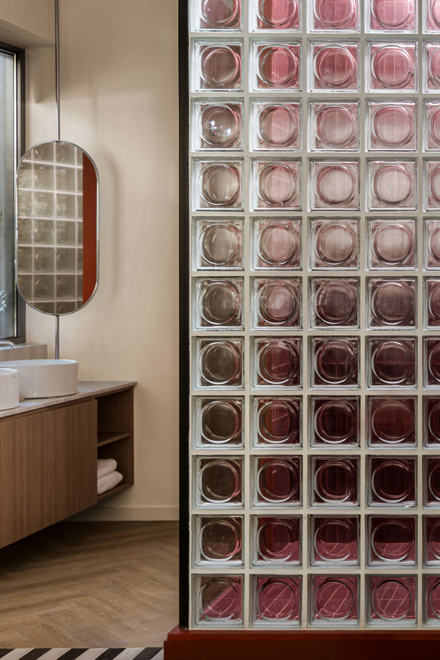 Glass block partition dividing living and sleeping areas in the apartment.