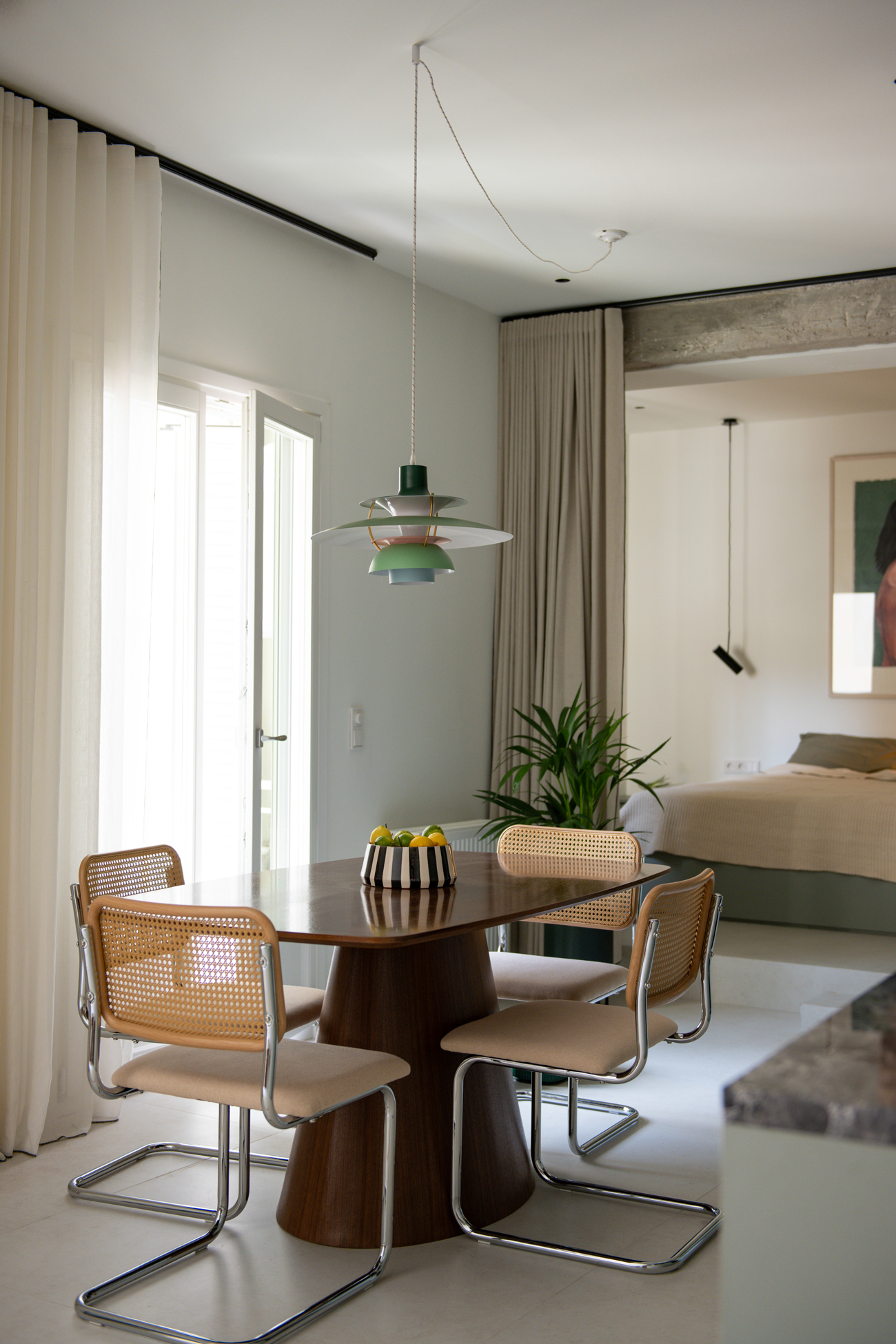 Dining area positioned beside full-height glazing overlooking the shared courtyard.
