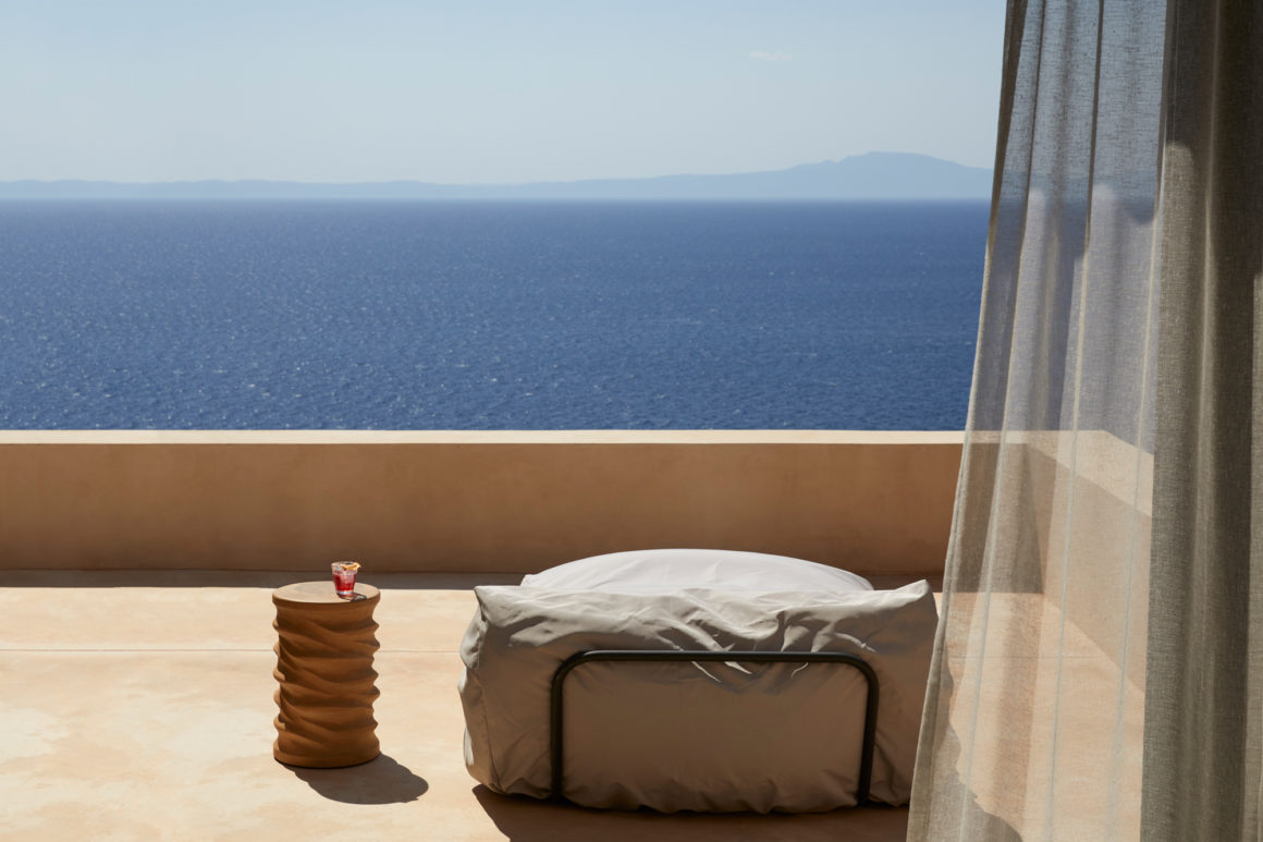 Bedroom with sliding glass doors opening towards uninterrupted views of the sea.