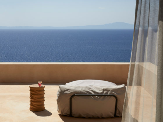 Bedroom with sliding glass doors opening towards uninterrupted views of the sea.
