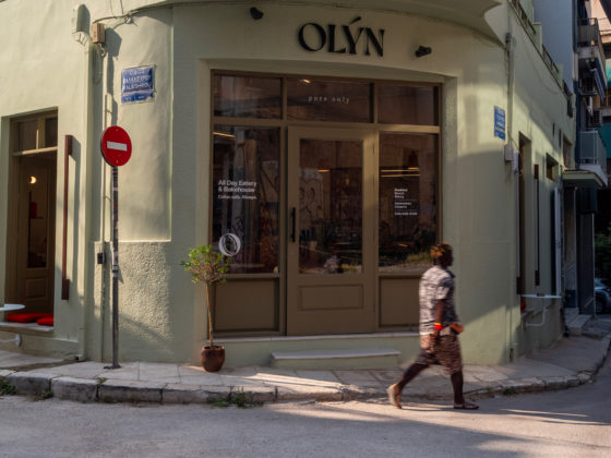 Exterior view of OLYN, a contemporary gluten-free bakery by Karn Studio, with fully opening façades on a corner site in Athens' Acropolis district.